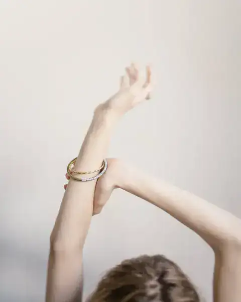 Girl with arms up showcasing her stylish bracelets